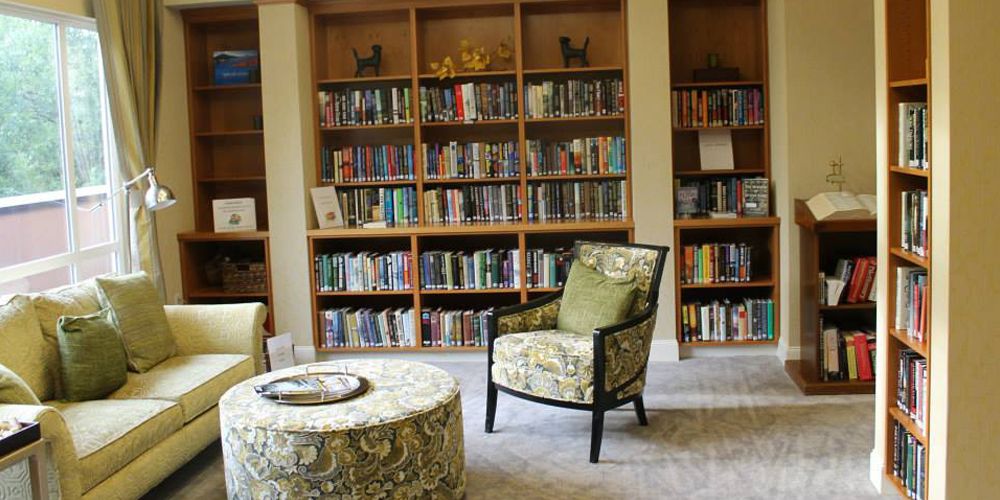 A cozy library corner with comfortable seating and bookshelves filled with a variety of books.
