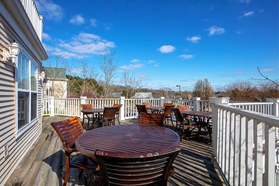 A scenic outdoor patio with tables and chairs under a clear blue sky.