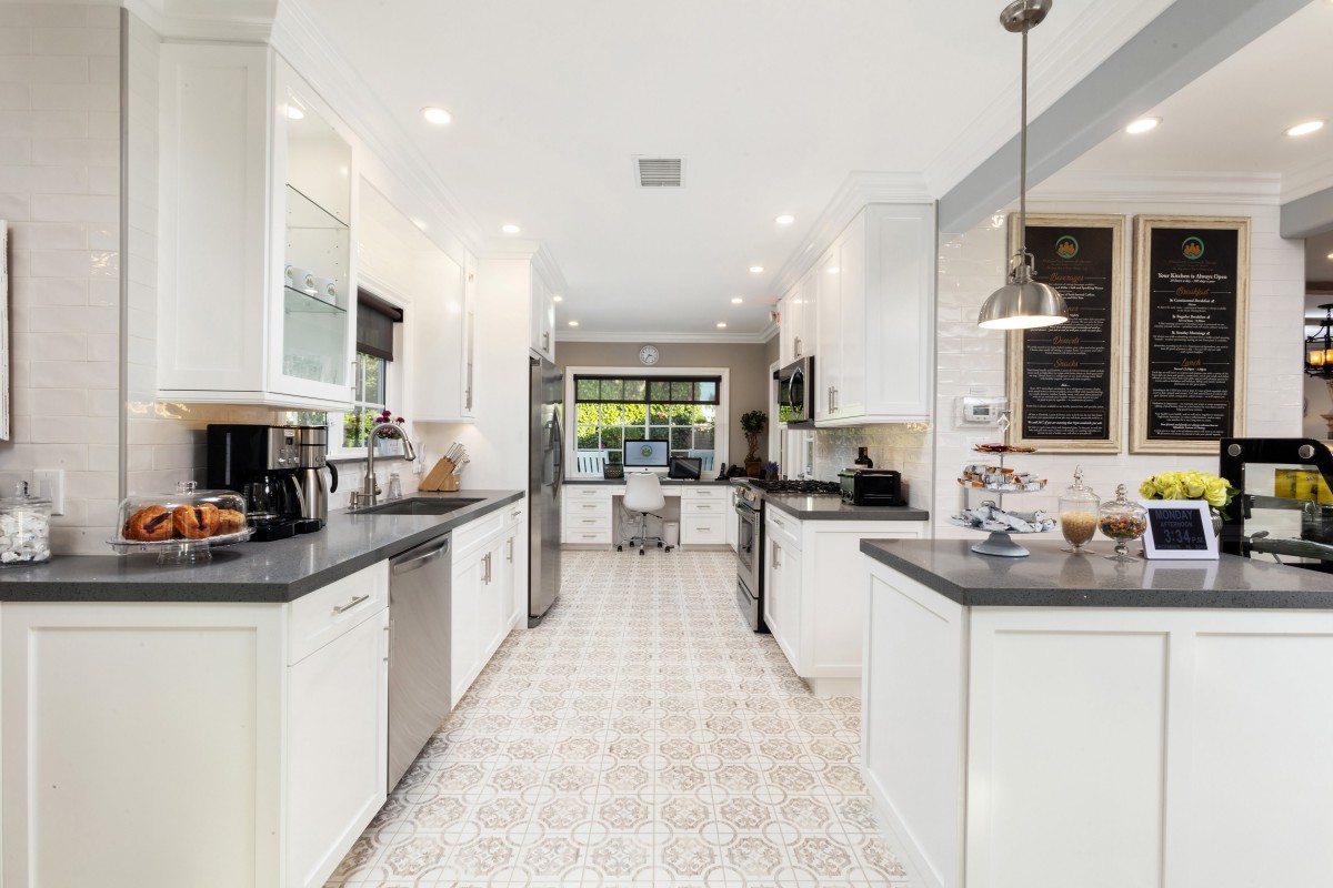 A modern kitchen with white cabinets and stainless steel appliances.