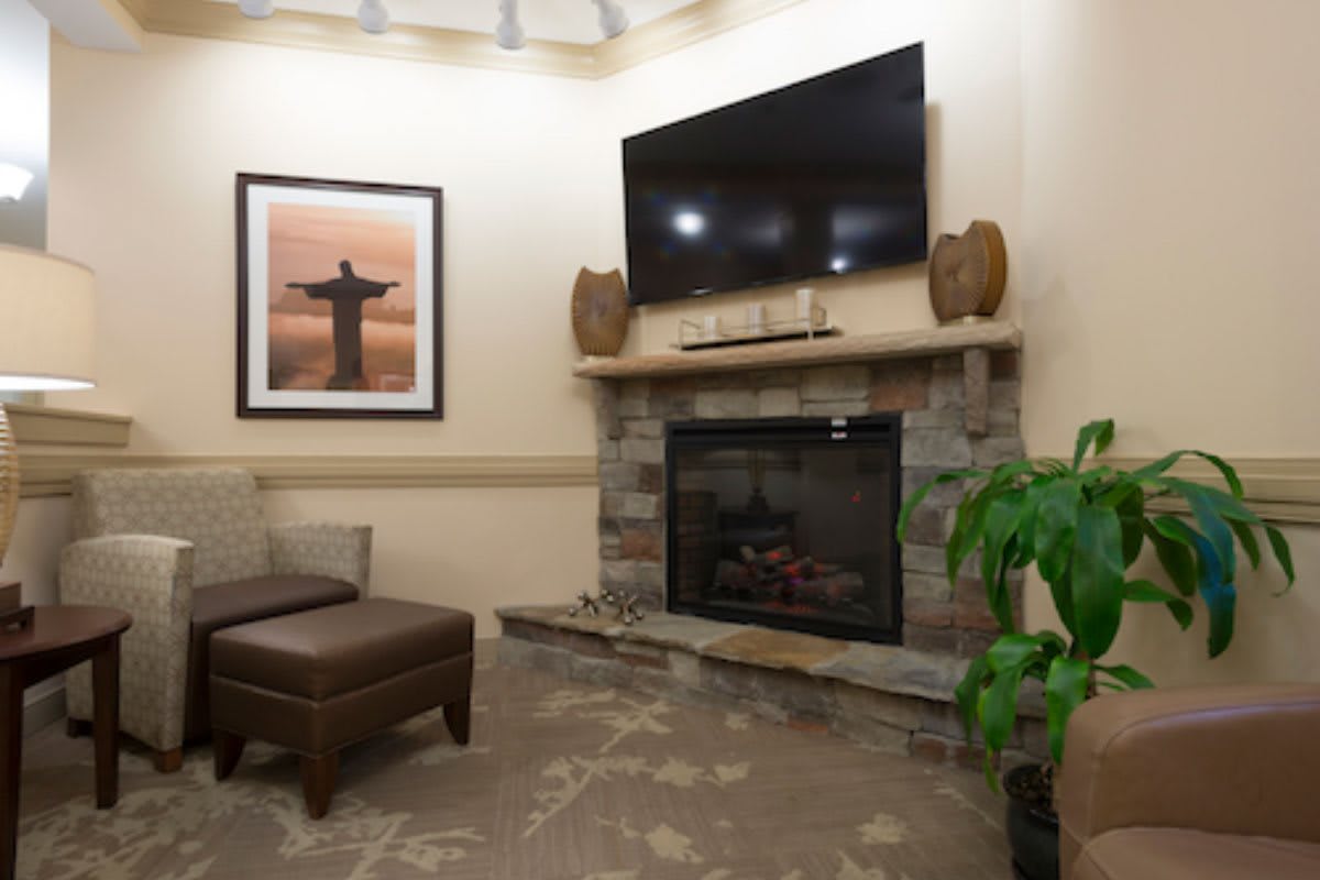 A cozy living room with a fireplace, television, and comfortable seating.