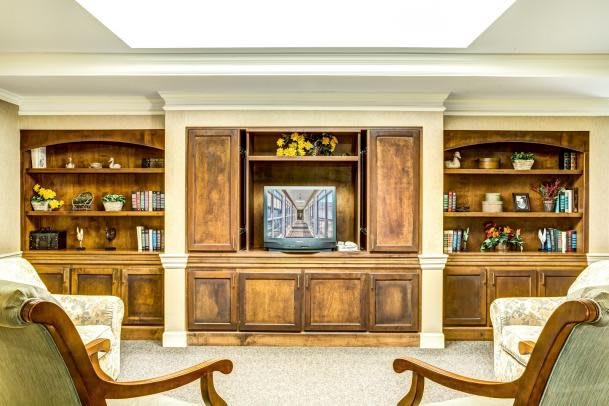 A traditional living room featuring wooden bookshelves and a TV cabinet.