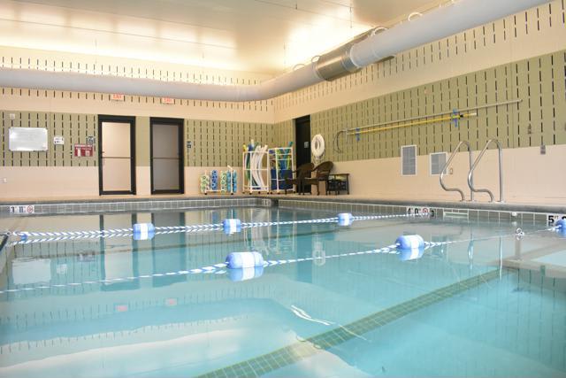 An inviting indoor swimming pool with clear water and floating lane dividers.