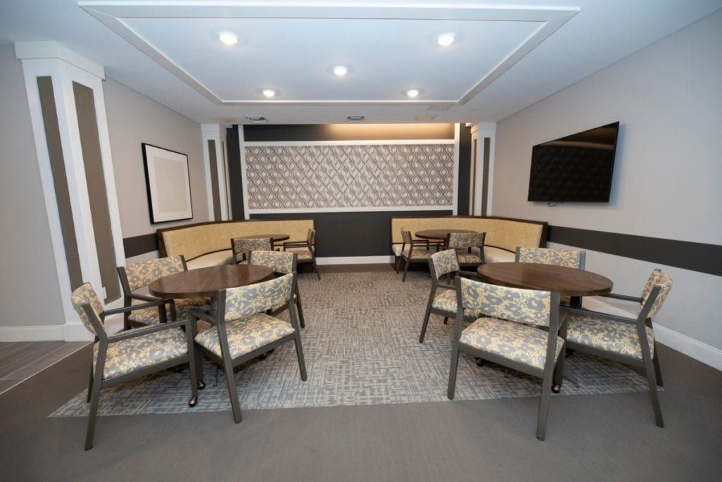 A modern dining area with several tables and chairs, featuring stylish decor and a mounted television.