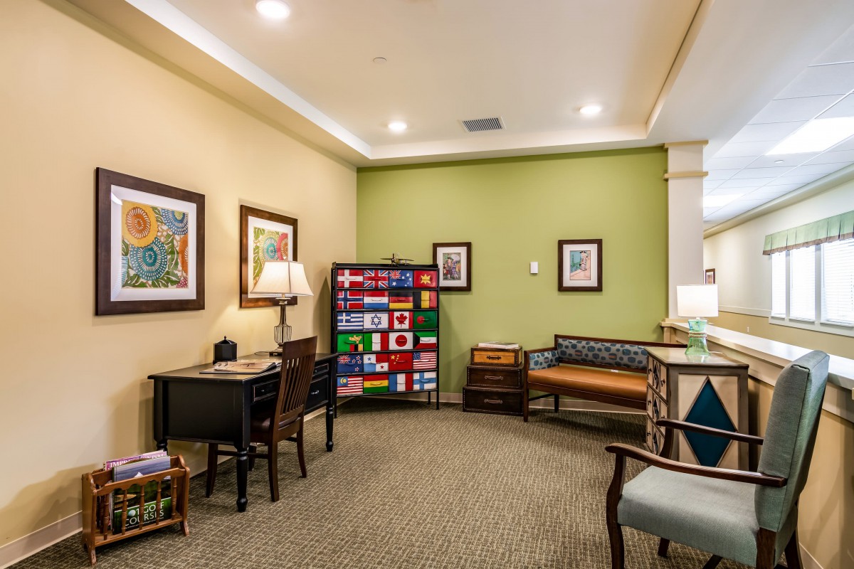 A cozy waiting room with colorful flags, artwork, and various seating options.