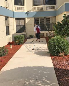 A person walking along a garden pathway outside a building.