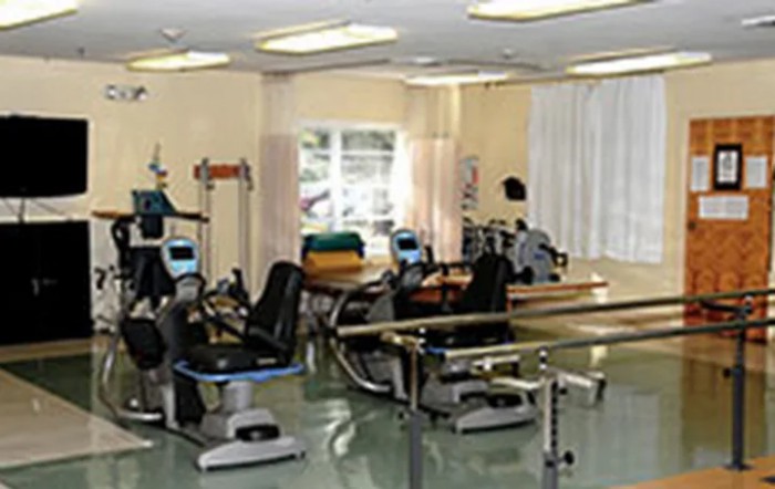 A rehabilitation room equipped with various exercise machines for physical therapy.