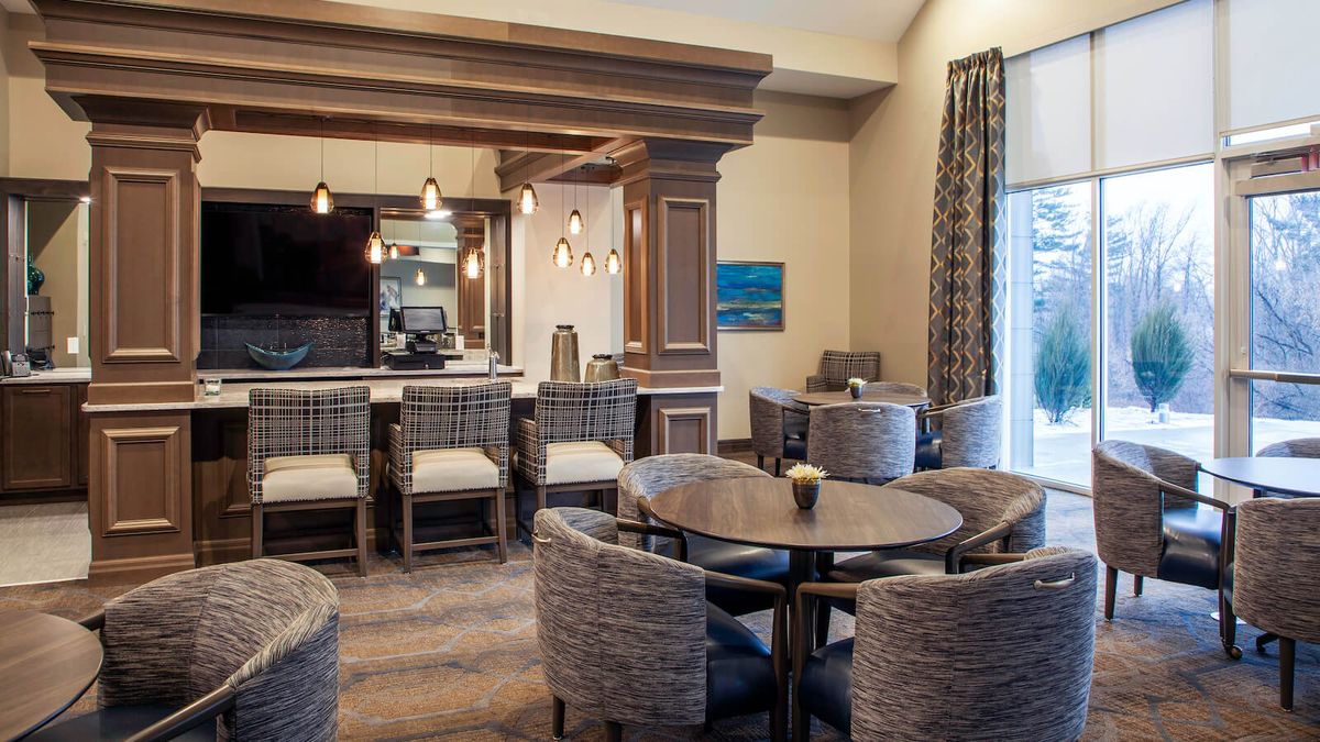 A modern hotel lounge with a bar area and cozy seating arrangements.