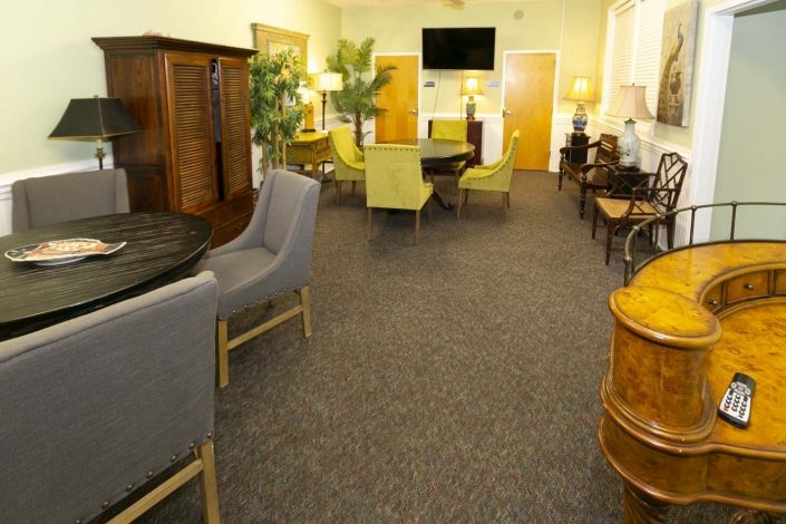 A cozy lounge area with various seating options, tables, and decorative plants.