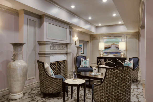 A well-furnished living room with elegant seating and a cozy fireplace, accented by modern lighting and artwork.
