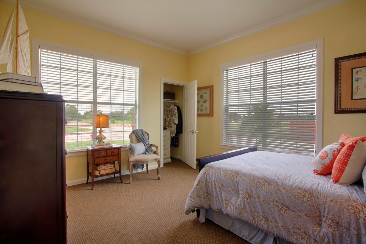 A cozy bedroom with large windows allowing plenty of natural light.