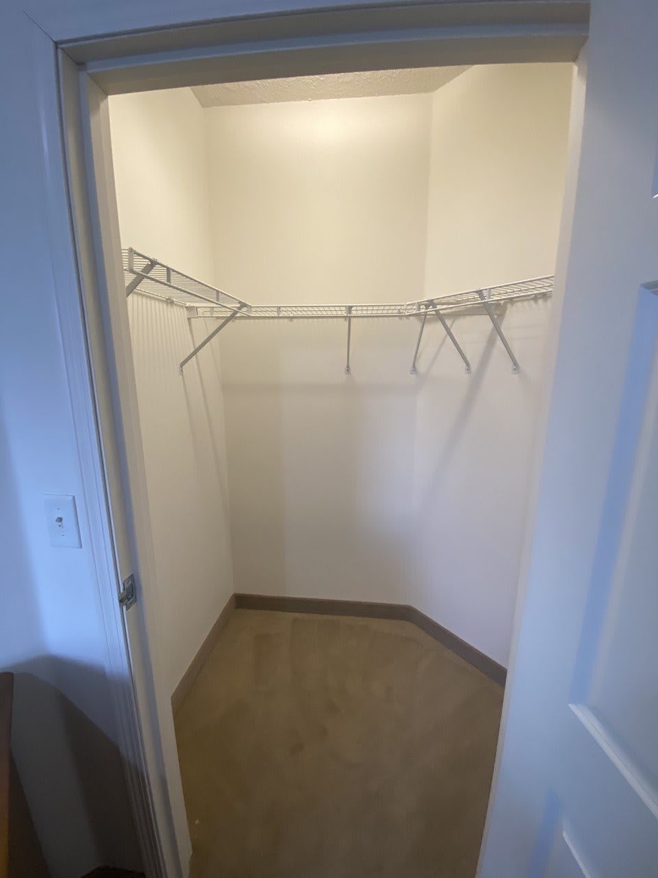 An empty walk-in closet with wire shelving.