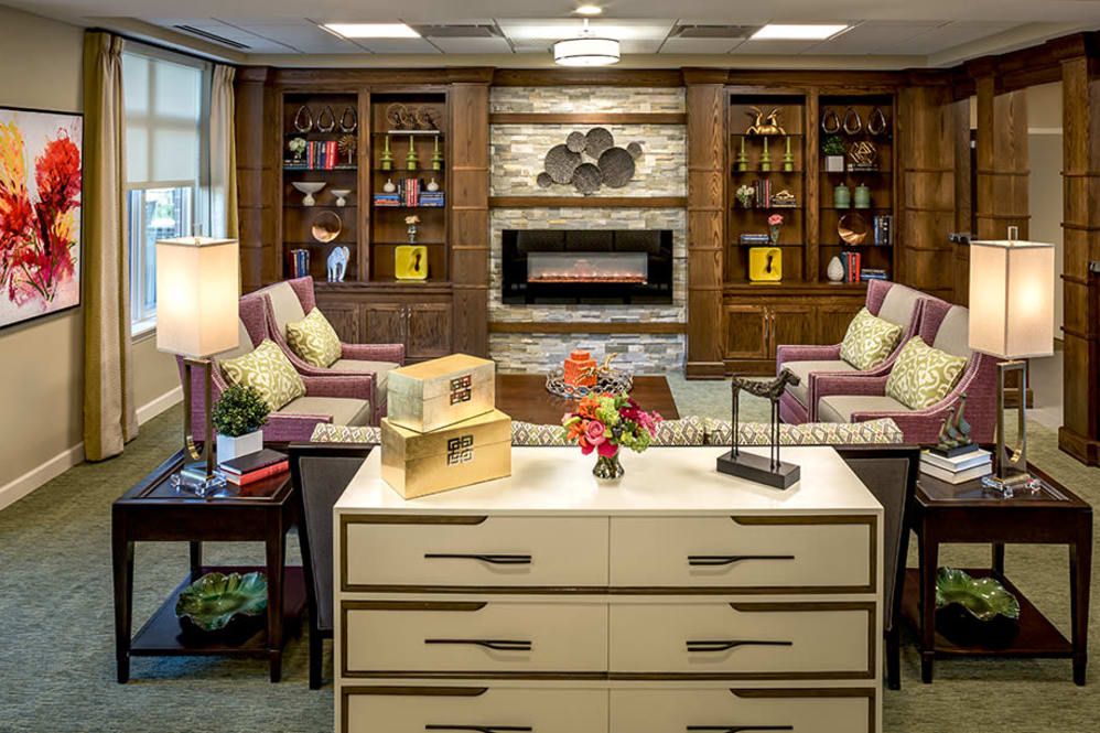 A cozy living room with a fireplace and built-in bookshelves, featuring comfortable seating and elegant decor.