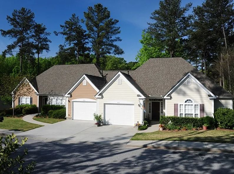 A suburban house with a driveway surrounded by trees.