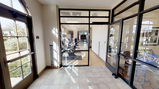 A stylish and modern office space featuring glass doors and a well-lit design.