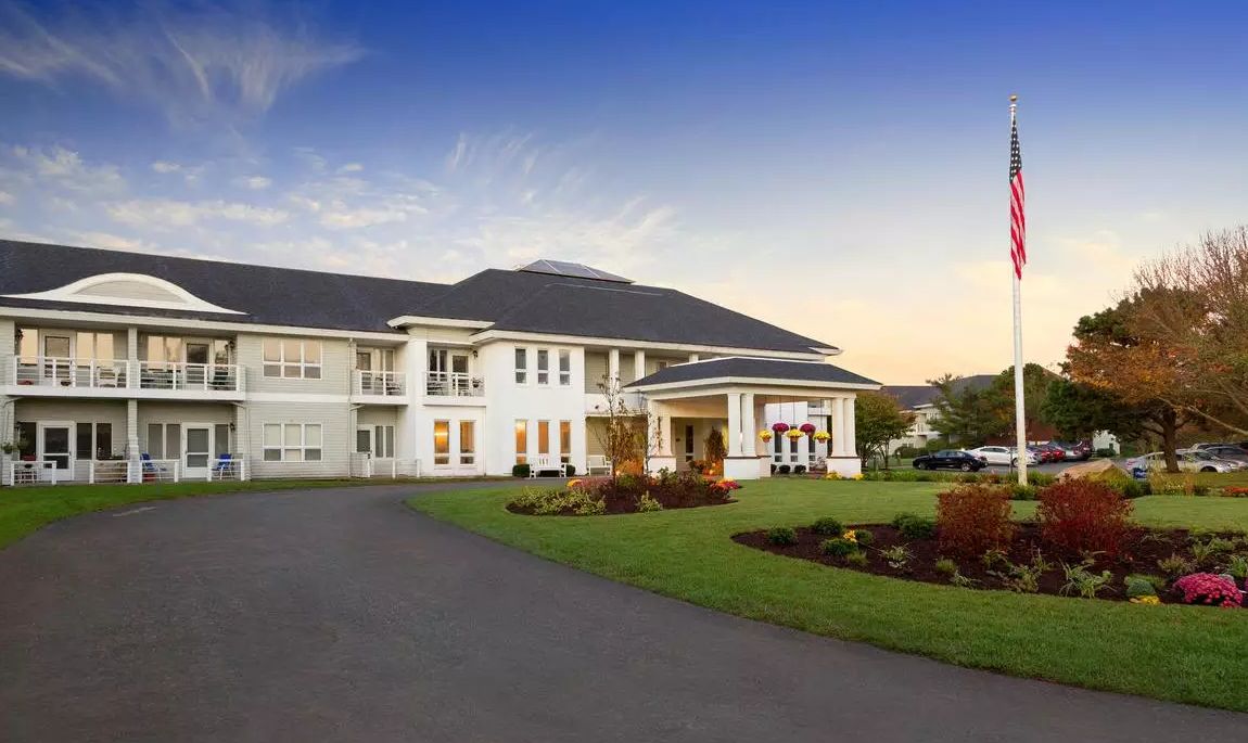 A large and elegant mansion with a well-maintained driveway and garden.