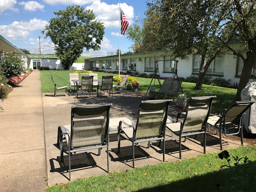 A peaceful outdoor seating area featuring a fire pit and an American flag, perfect for relaxation.