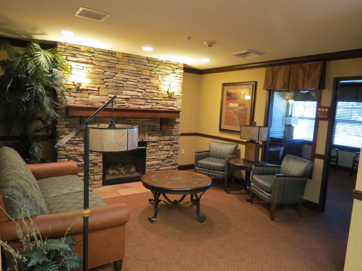 A cozy lounge area with comfortable seating and a stone fireplace.