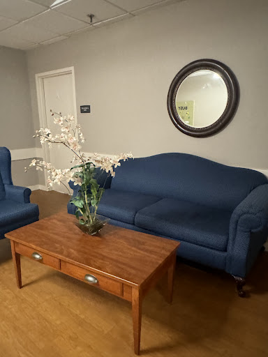 A cozy living room setup featuring blue sofas, a wooden coffee table, and decorative accents.