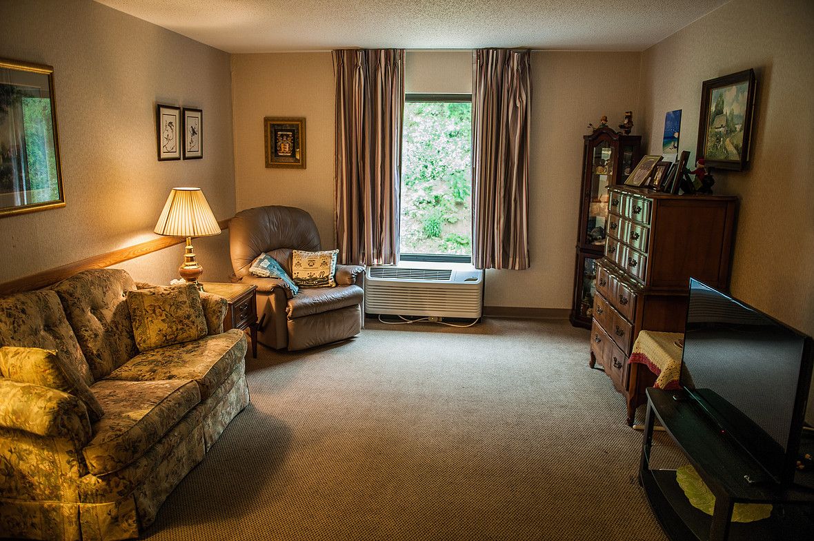 A cozy living room with comfortable seating, a soft carpet, and warm lighting.