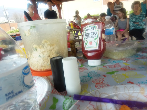A festive outdoor gathering with snacks like popcorn and ketchup on the table.
