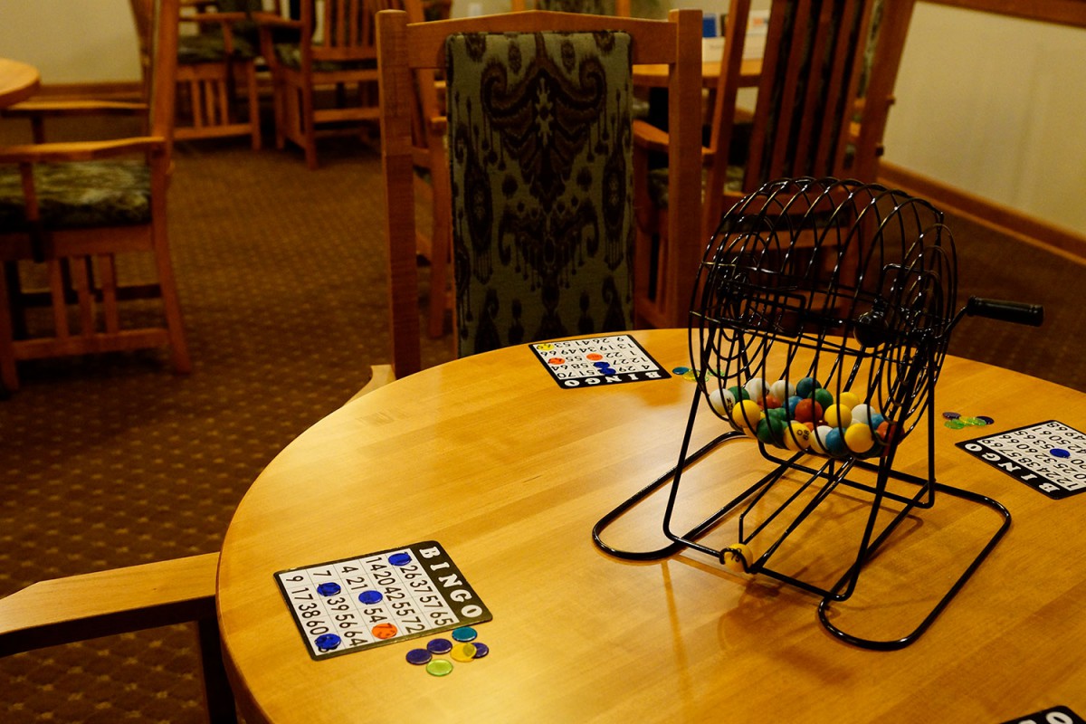 A table set up for a game of bingo, complete with bingo cards and a cage for drawing numbers.
