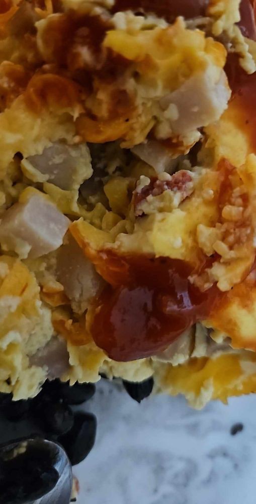 An omelette topped with cheese and sauce.