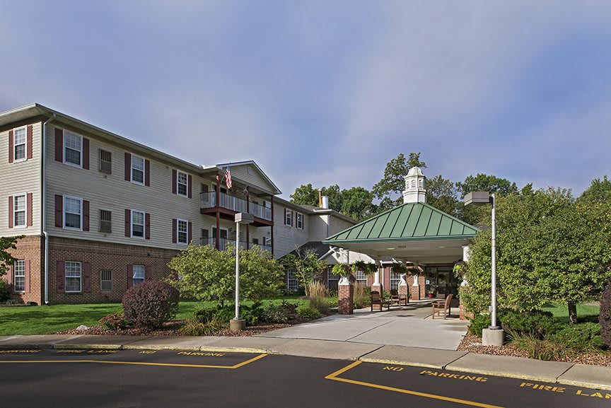 A residential building with a covered entrance and landscaping.