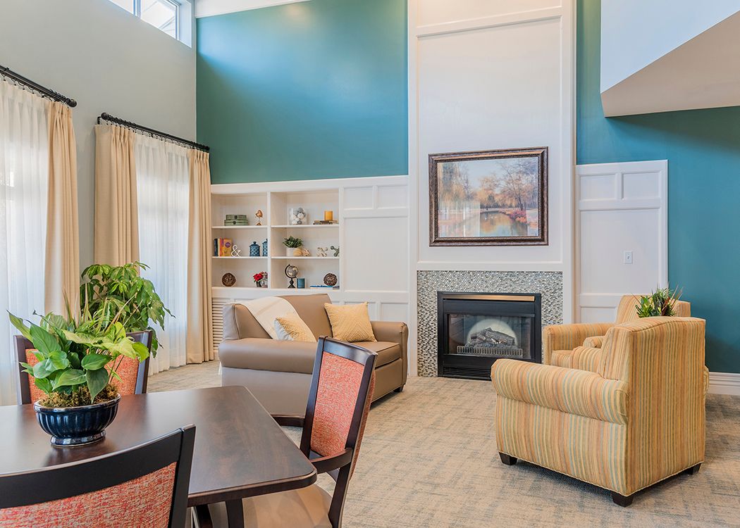 A cozy living room featuring a fireplace, comfortable seating, built-in bookshelves, and decorative accents.