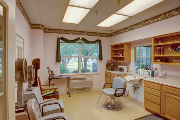 A warmly lit waiting room with chairs and a large window.