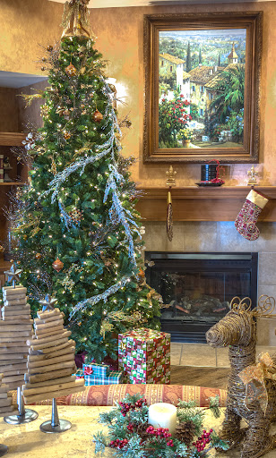 A beautifully decorated Christmas tree surrounded by wrapped presents and a cozy fireplace.