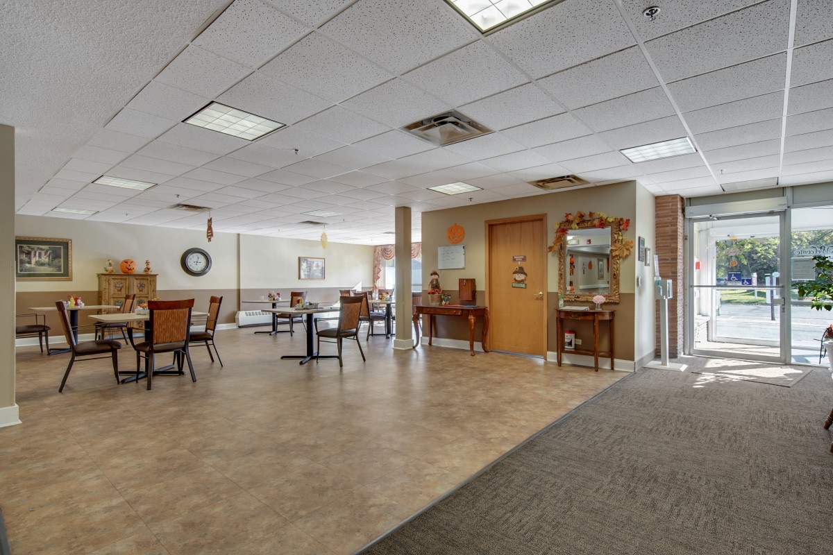 An open room with chairs and tables, featuring ceiling lights and decorative elements.