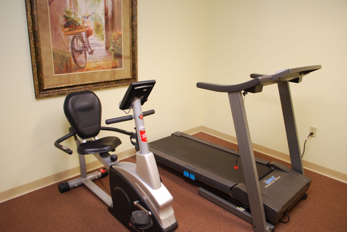 A small fitness room featuring an exercise bike and a treadmill.