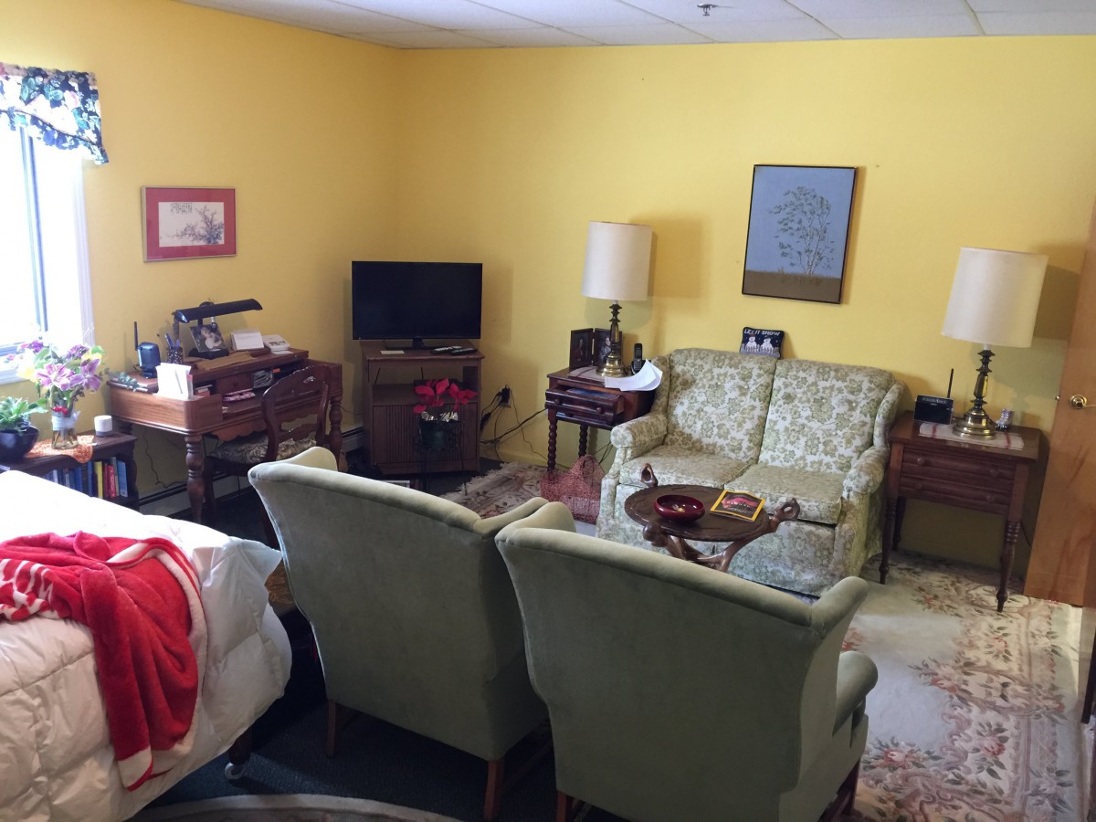 A cozy living room with vintage furniture and yellow walls.