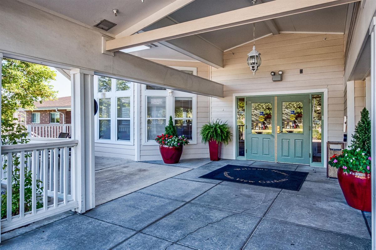 A welcoming entrance with a covered walkway and potted plants.