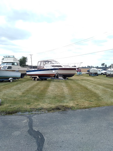 A collection of boats parked on grass at a marina.