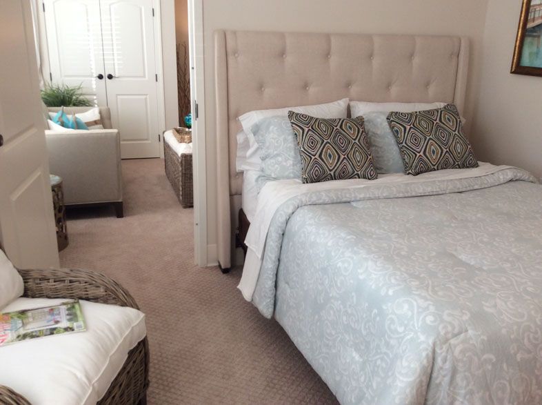 A cozy and well-decorated bedroom featuring a plush bed with patterned pillows and a soft comforter.
