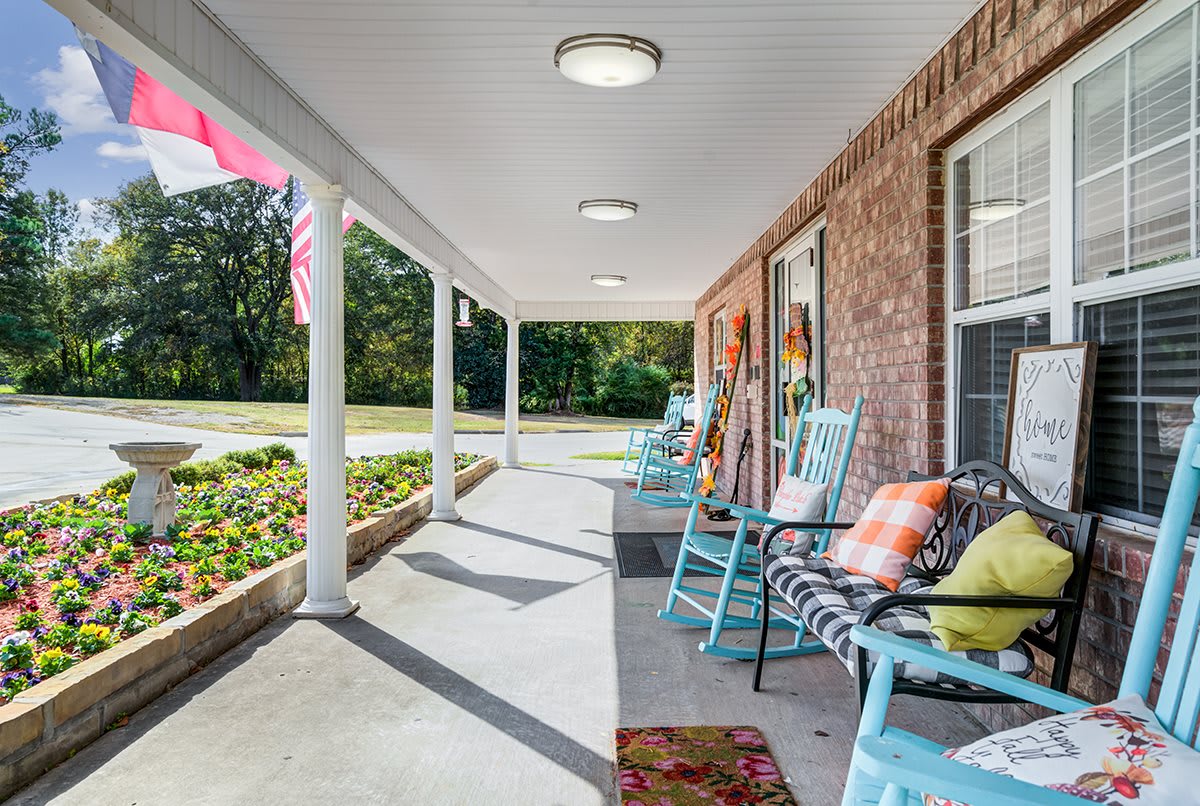 A cozy porch with rocking chairs and colorful cushions on a sunny day.