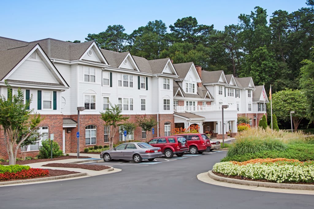 A row of townhouses with a parking lot in a suburban area.