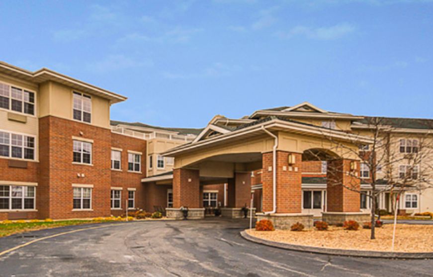 Modern brick building with a prominent entrance and clear sky.