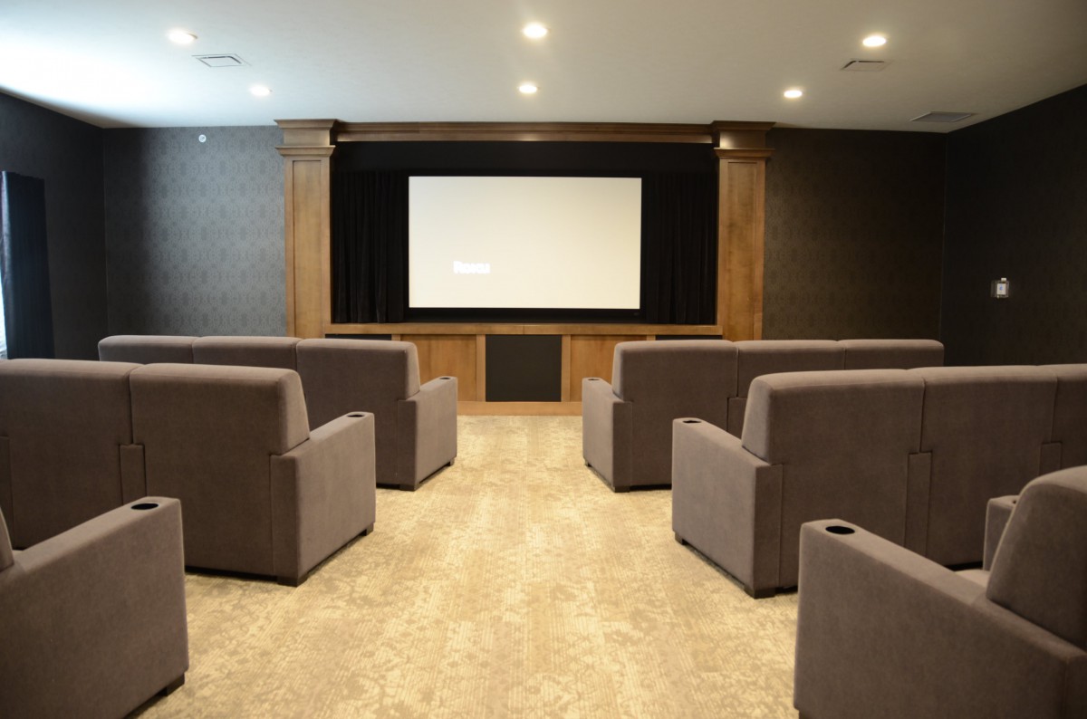 A cozy home theater setup with plush seating and a large screen.