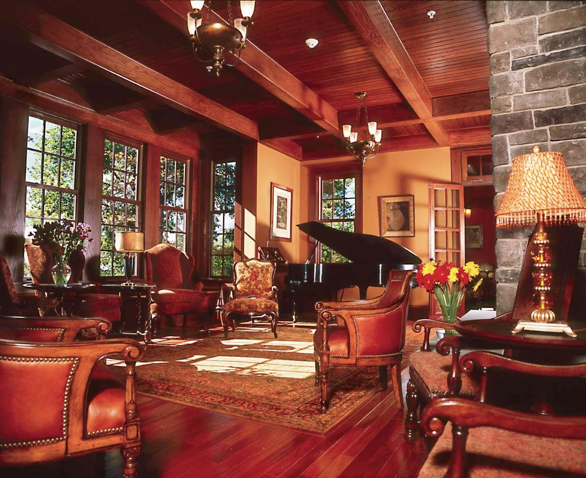 A luxurious and elegantly designed living room featuring a grand piano and wooden furniture.