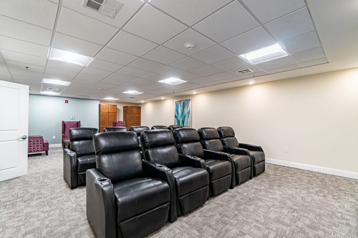 A modern home theater with leather recliner seating arranged in two rows.