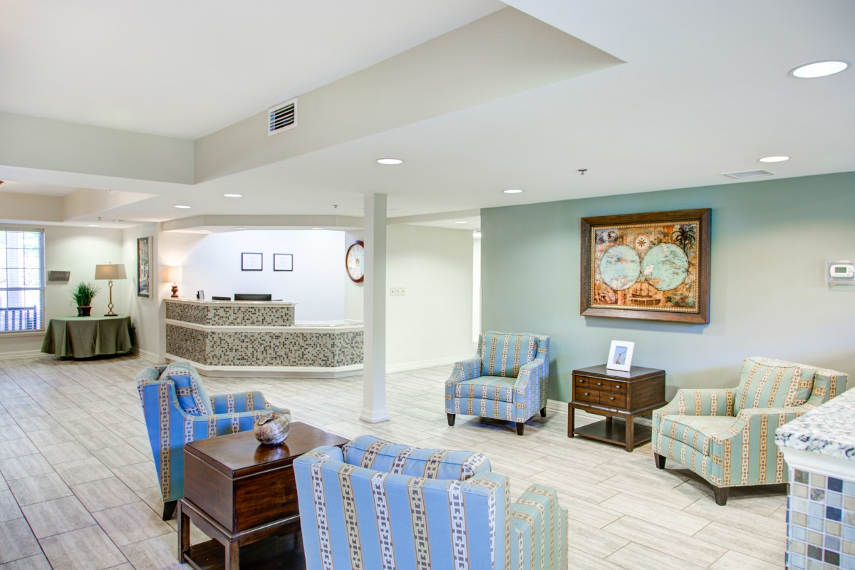 A modern lobby area with comfortable seating and a reception desk in the background.