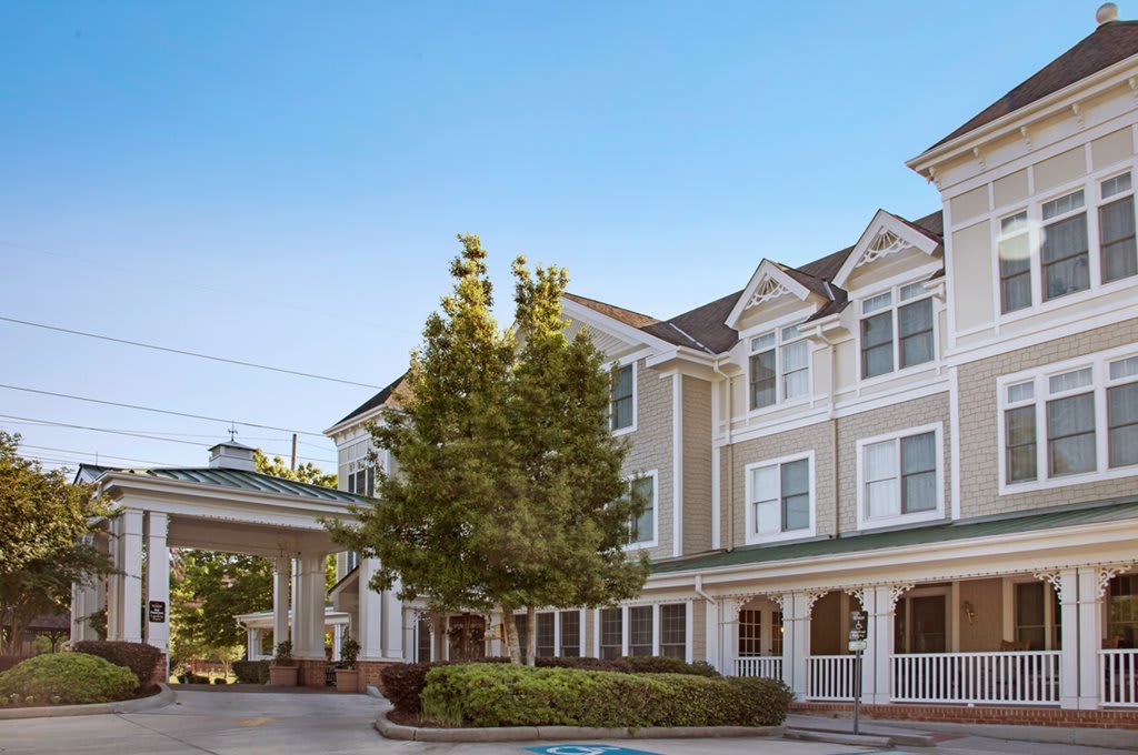 A daytime view of a hotel building with classic architecture and surrounding trees.