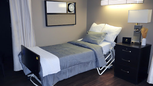 A neatly arranged hospital bed in a well-lit room, designed for comfort and care.