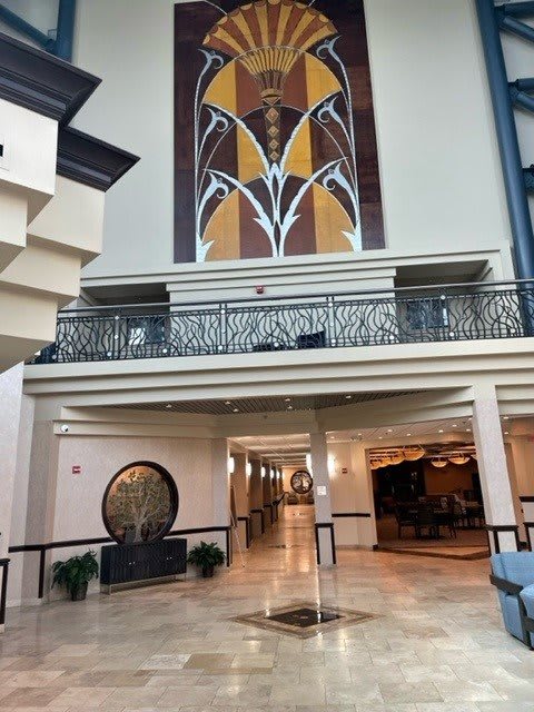 Modern hotel lobby with art deco elements and striking artwork.