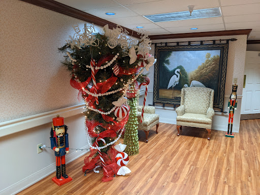 A festive holiday scene featuring a beautifully decorated Christmas tree and a nutcracker figure, set against an elegant backdrop with artwork.