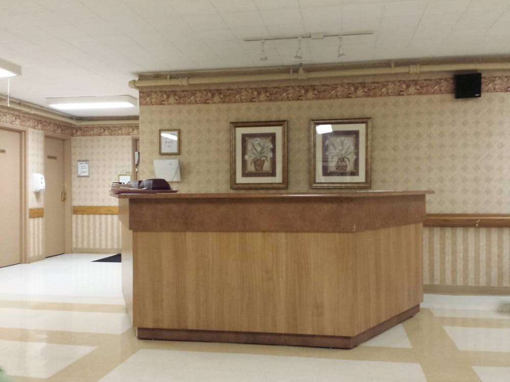 An empty reception desk in a lobby area with decorative wall art.