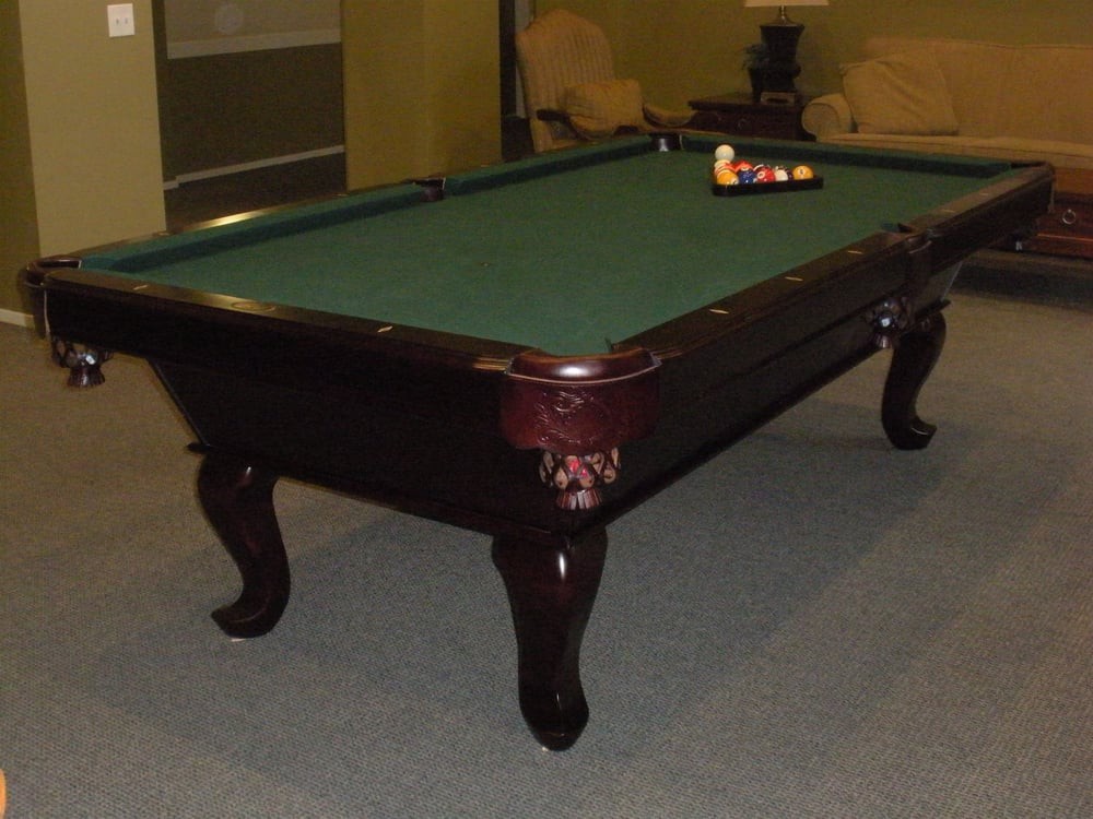 A well-maintained pool table set up for a game in a cozy room.