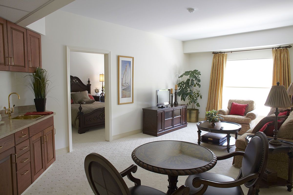 A cozy living room with elegant furniture and a view into the adjacent bedroom.